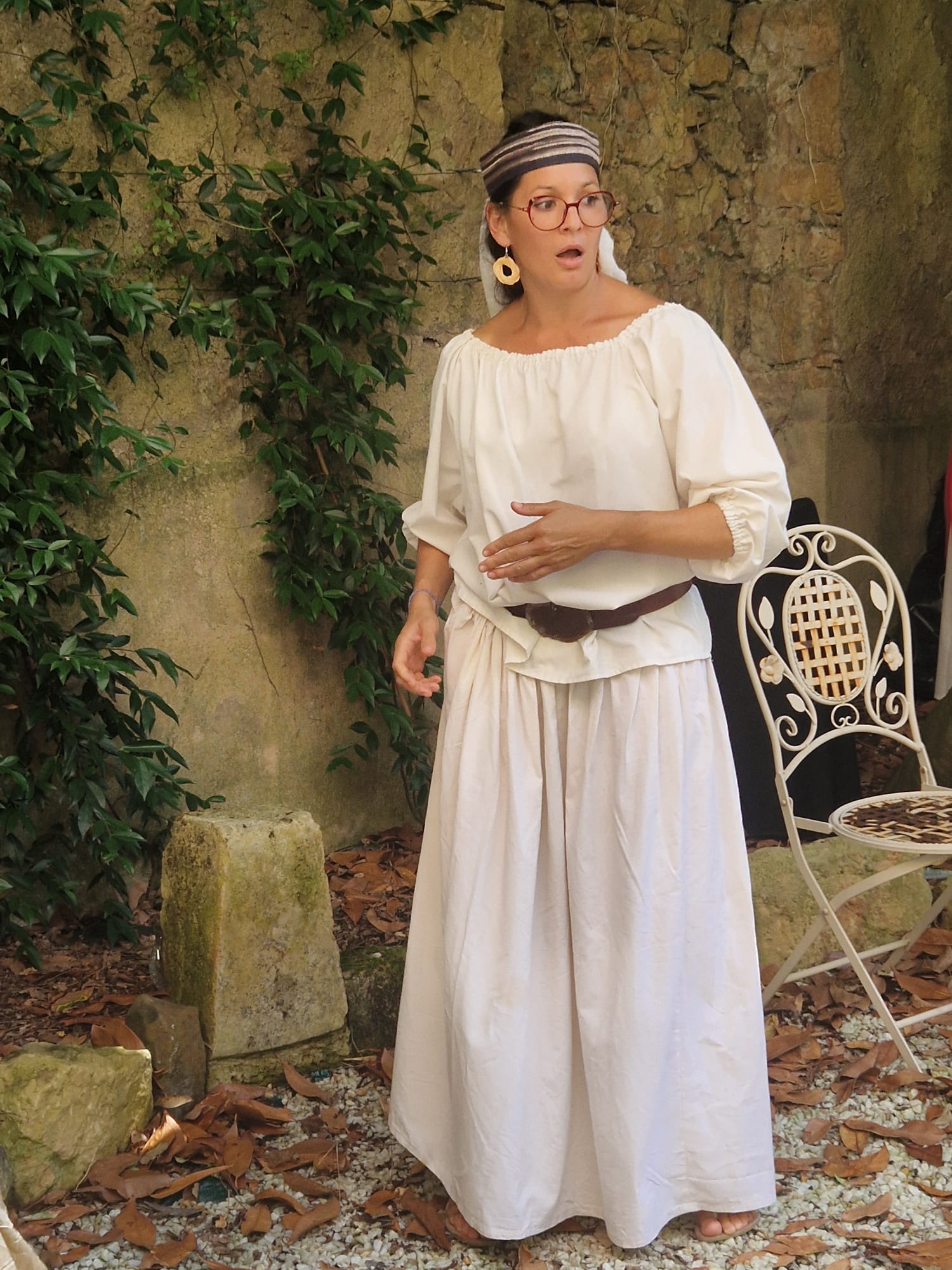 Aurélie en costume, contant dans un jardin de pierre à Belvès