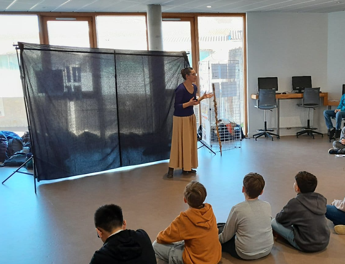 Séance de conte devant une classe d'enfants